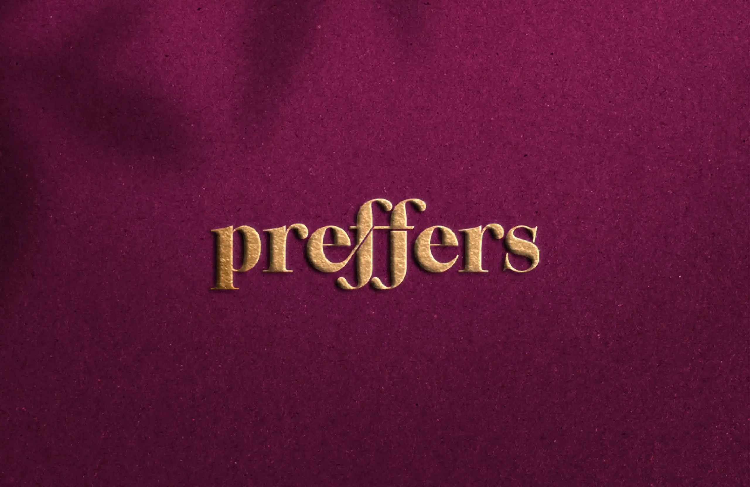 Preffers luxury jewellery brand logo in gold on rich burgundy textured background
