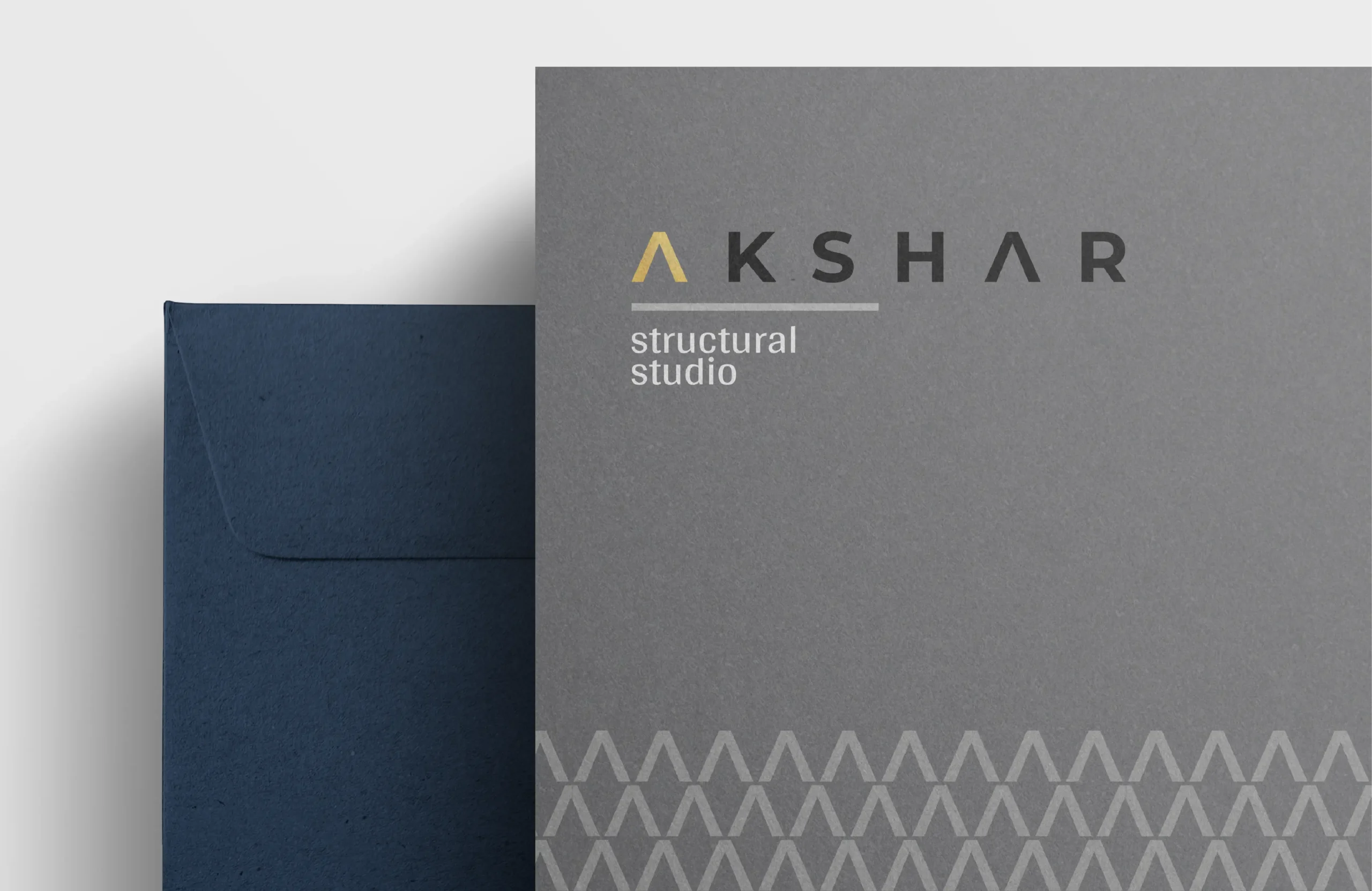 AKSHAR Structural Studio branded folder cover in grey with logo and patterned strip, placed next to a dark envelope.