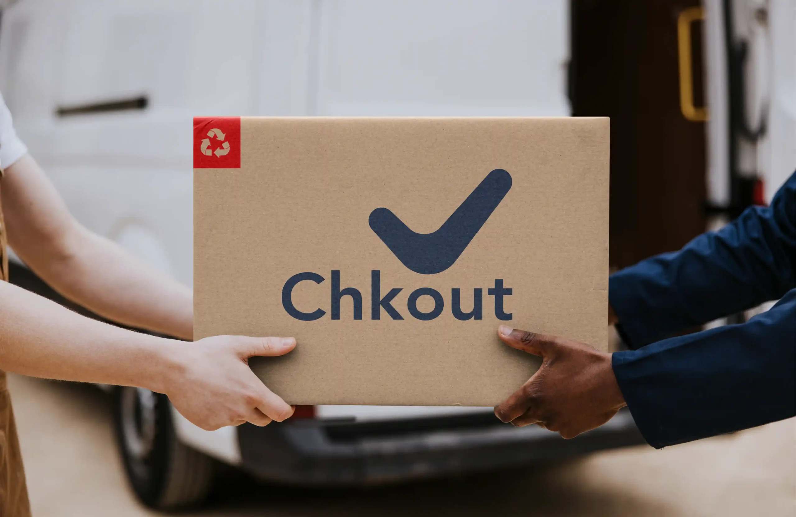 Hands exchanging a Chkout branded cardboard delivery box, representing reliable household essentials delivery.