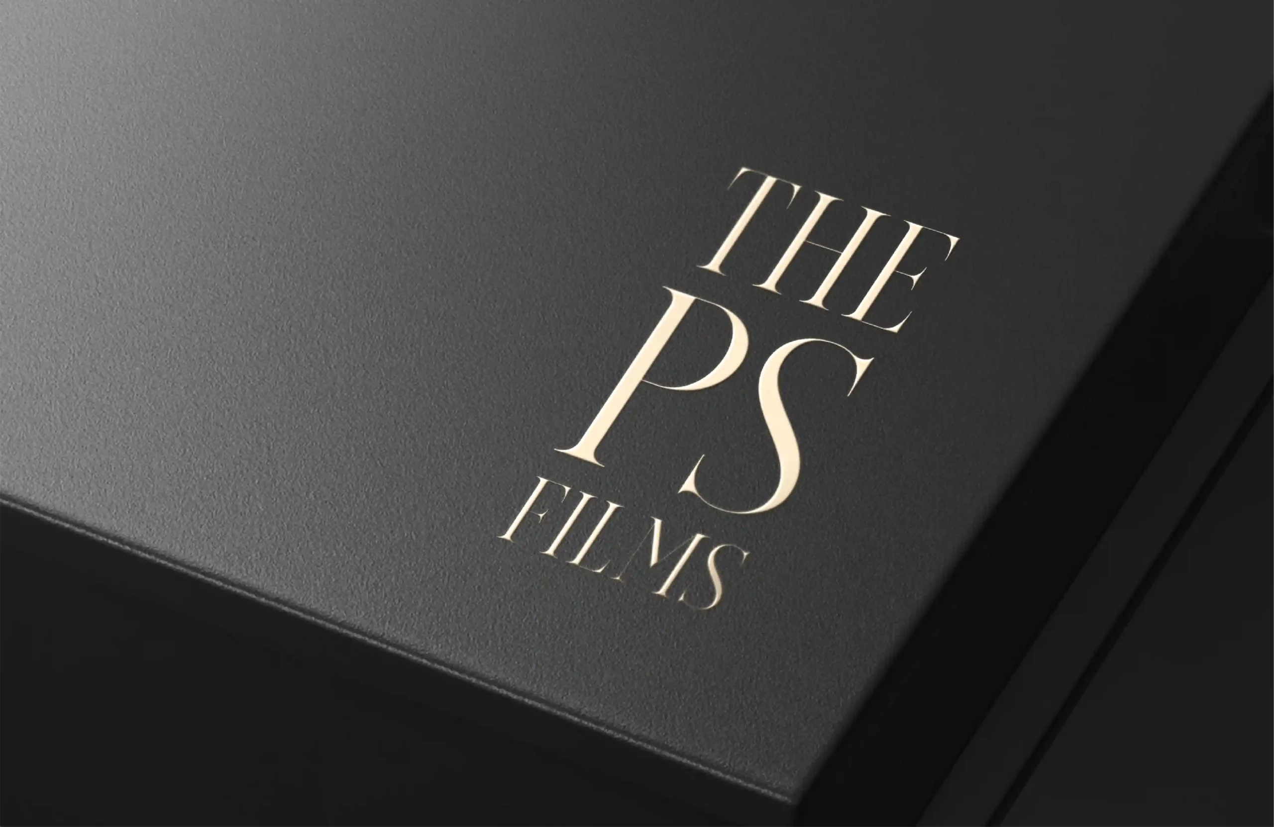 Elegant The PS Films logo mockup embossed in gold on a premium black textured surface for branding presentation.