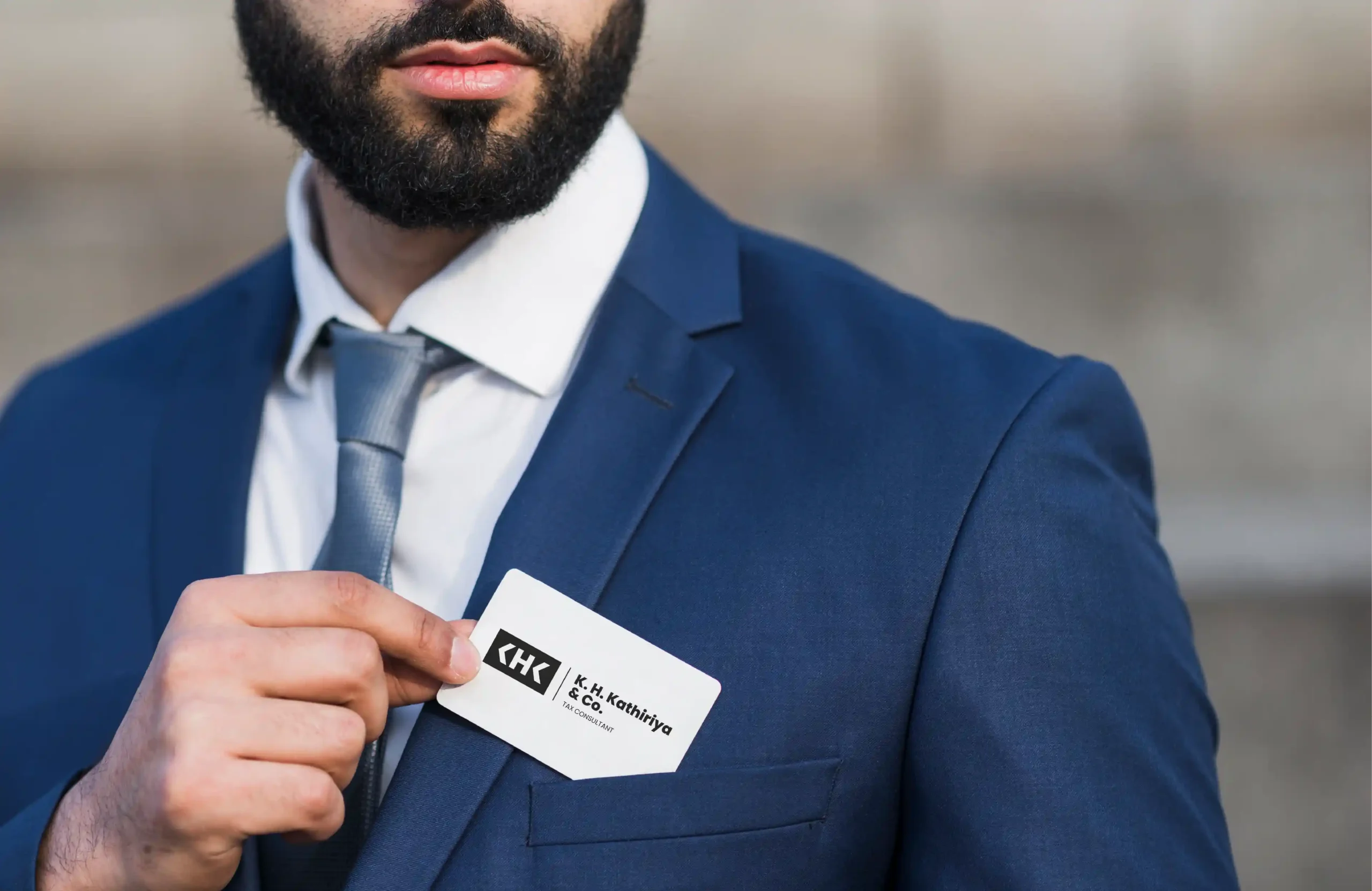 Business professional holding a K. H. Kathiriya & Co. tax consultant business card.